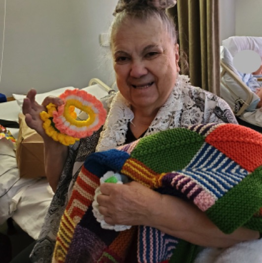 Maria shares her knitting with other residents in her home.